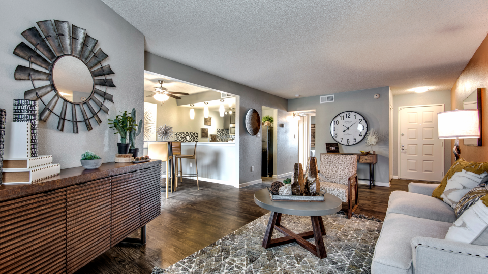 a living room with a large mirror and wood floors at The  Mark at 2600