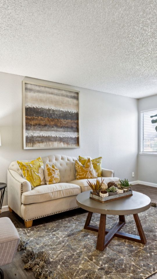 a living room with a couch, coffee table and chairs at The  Mark at 2600